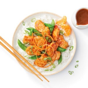 Back-of-pack photo of Gardein Mandarin Orange Crispy Chick’n served over rice with snap peas, carrots, and fresh mandarin slices, styled and photographed by CPG food photographer Steve Hirsch.